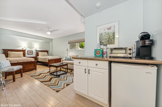 kitchen featuring white cabinetry, light hardwood / wood-style floors, fridge, and ceiling fan