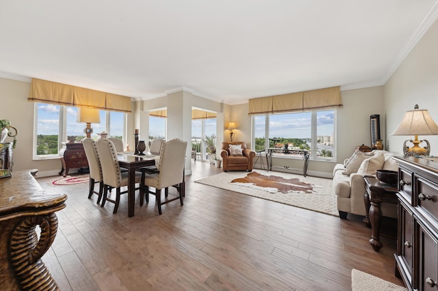 dining space with crown molding, dark wood-type flooring, and a healthy amount of sunlight