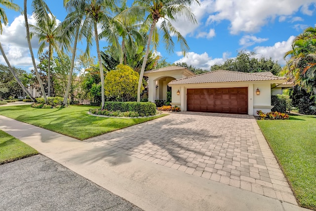 mediterranean / spanish-style home with a front lawn and a garage