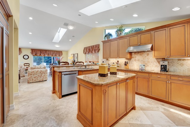 kitchen featuring vaulted ceiling with skylight, a kitchen island, stainless steel dishwasher, light tile flooring, and light stone countertops