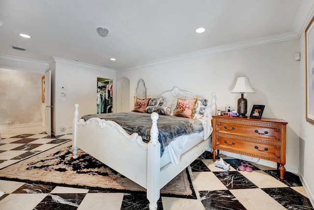 bedroom featuring crown molding, a walk in closet, a closet, and light tile floors