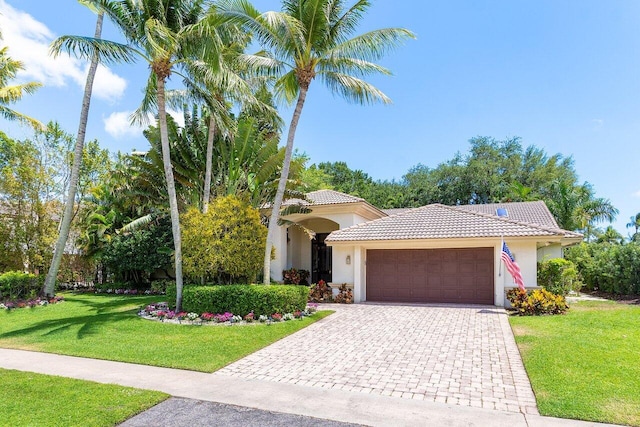 4590 Live Oak Blvd, Delray Beach, FL 33445 - view of front of home featuring an attached garage, a front lawn, stucco siding, and a tile roof