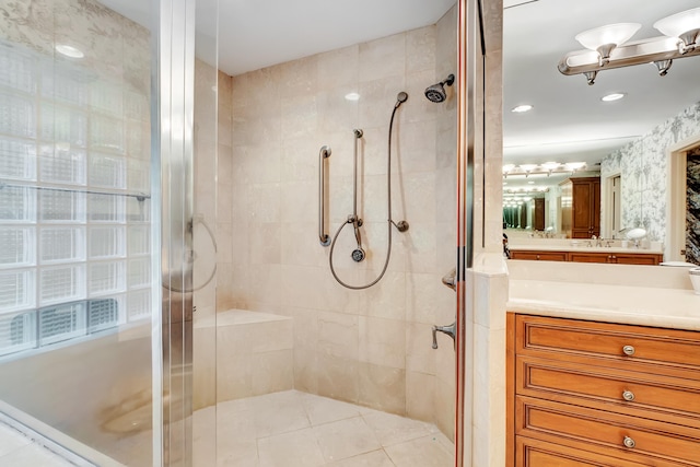 bathroom featuring a shower with shower door and vanity