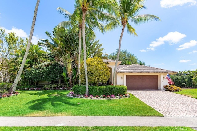 4590 Live Oak Blvd, Delray Beach, FL 33445 - view of front of property featuring a tiled roof, decorative driveway, a front lawn, an attached garage, and stucco siding