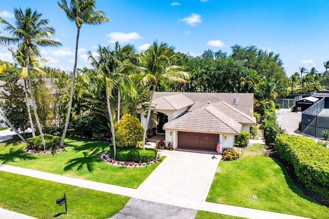 4590 Live Oak Blvd, Delray Beach, FL 33445 - view of front of house with an attached garage, a tile roof, stucco siding, a front yard, and decorative driveway