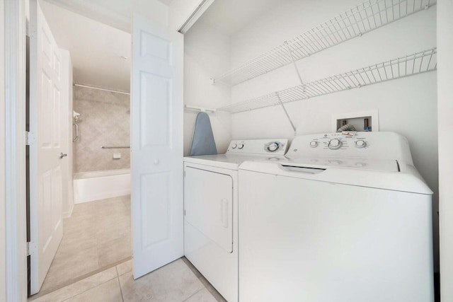 washroom with separate washer and dryer and light tile patterned floors