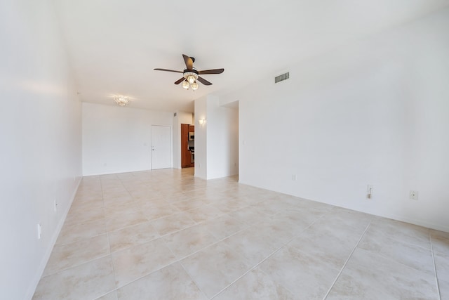 empty room with ceiling fan and light tile patterned floors