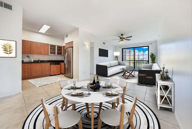 dining space featuring light tile patterned floors, sink, and ceiling fan