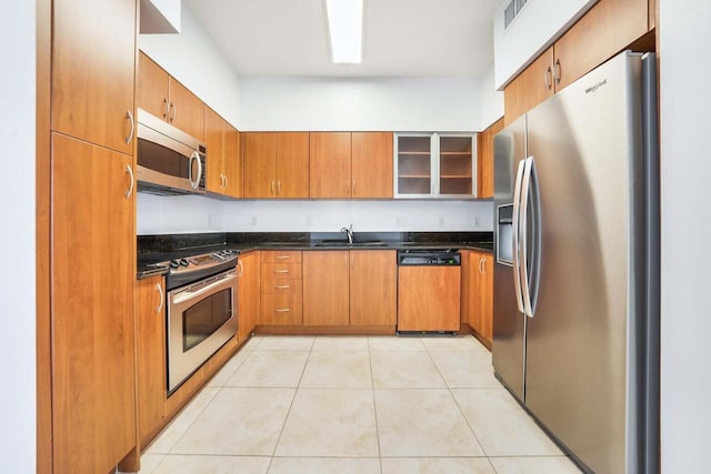 kitchen with appliances with stainless steel finishes, light tile patterned flooring, and sink