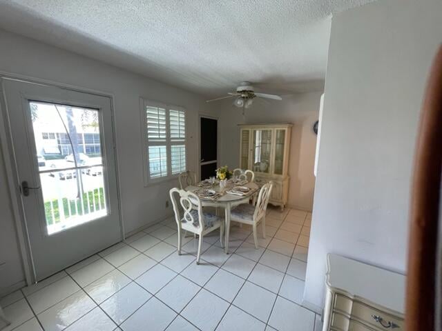 dining area with light tile floors, a textured ceiling, ceiling fan, and a wealth of natural light