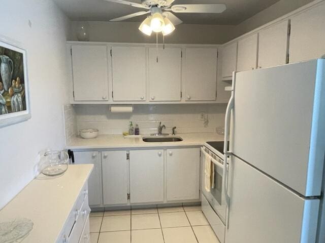 kitchen featuring white fridge, ceiling fan, light tile flooring, sink, and electric range oven