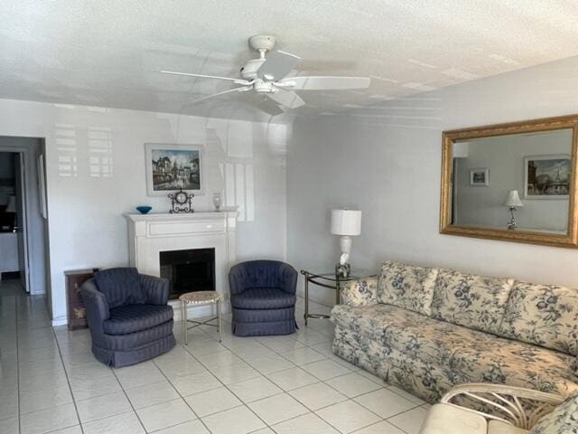 tiled living room with a textured ceiling and ceiling fan