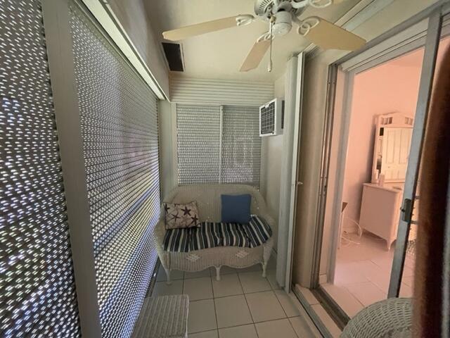 balcony featuring a wall mounted air conditioner and ceiling fan