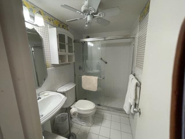 bathroom featuring tile walls, toilet, ceiling fan, sink, and tile floors