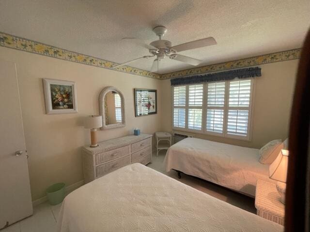 bedroom with ceiling fan and a textured ceiling