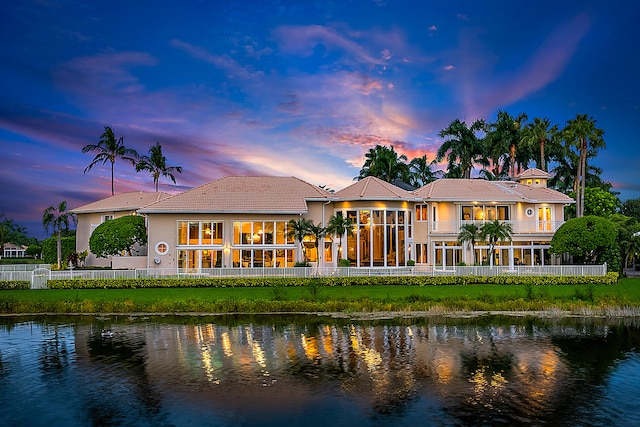 back house at dusk featuring a water view