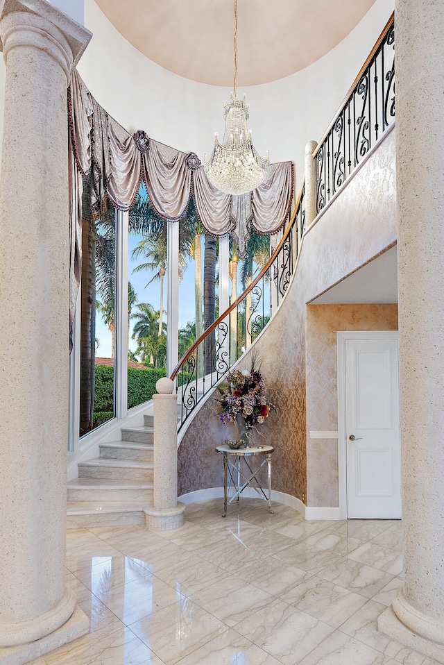 stairs featuring decorative columns, light tile flooring, and a chandelier