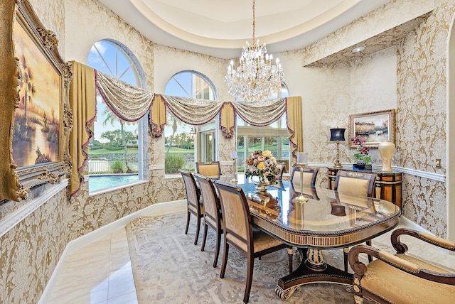 tiled dining area with a raised ceiling, a notable chandelier, and a high ceiling