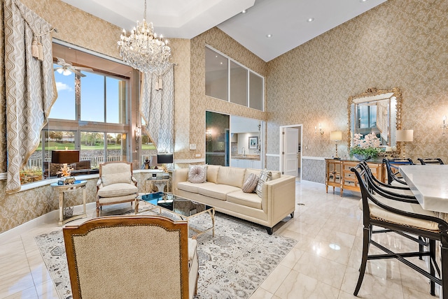 tiled living room with ceiling fan with notable chandelier and a towering ceiling