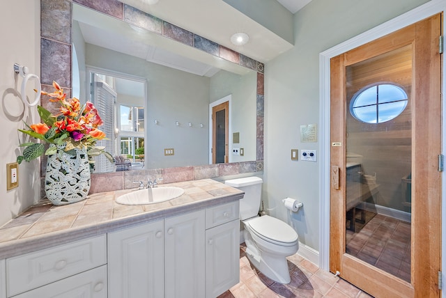 bathroom featuring toilet, tile flooring, and vanity