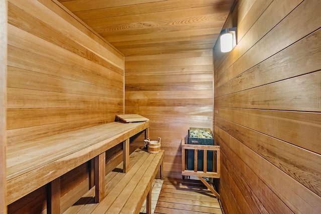 view of sauna / steam room with wood walls, wood ceiling, and hardwood / wood-style flooring