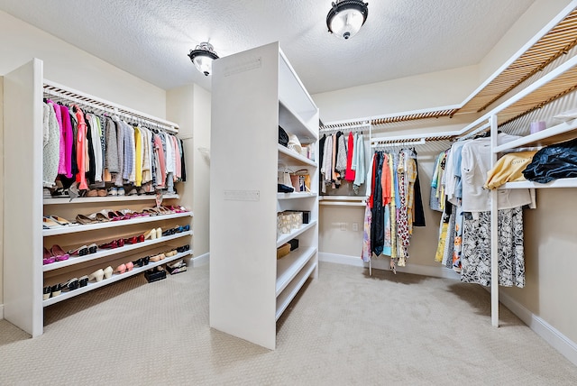 walk in closet with light colored carpet