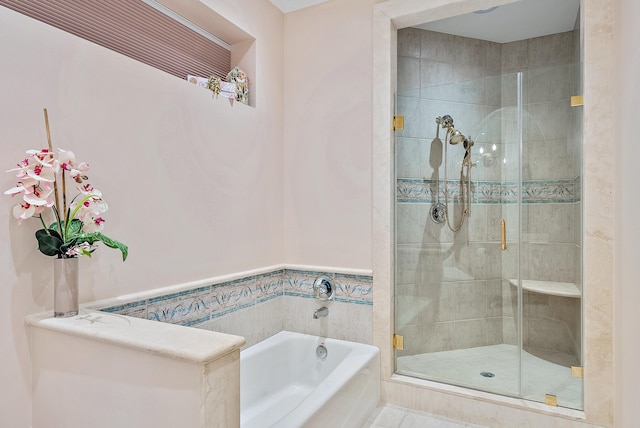 bathroom featuring shower with separate bathtub and tile floors