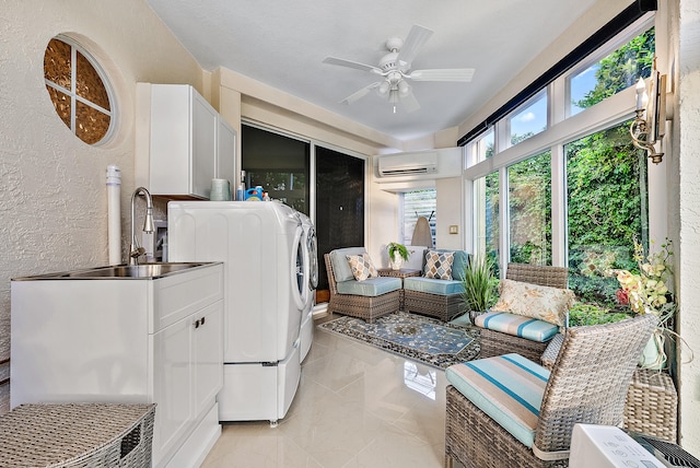 washroom with a wall unit AC, ceiling fan, light tile floors, sink, and washer / clothes dryer