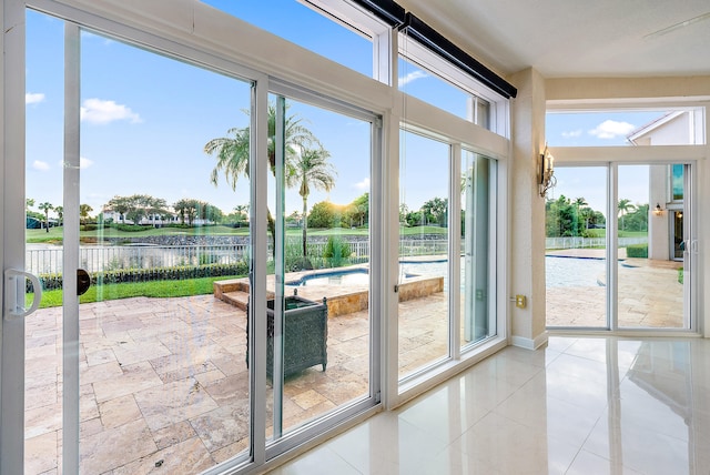 doorway to outside featuring light tile flooring and a healthy amount of sunlight