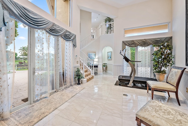 tiled foyer entrance featuring a towering ceiling