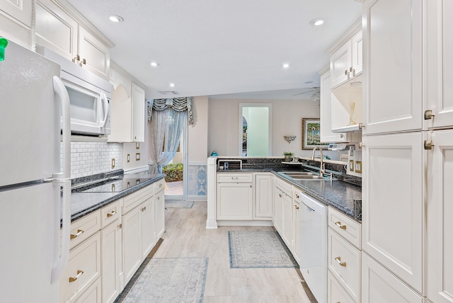 kitchen with white cabinetry, white appliances, sink, light wood-type flooring, and tasteful backsplash