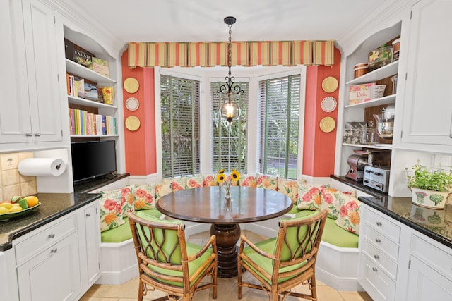 dining room featuring crown molding and light tile floors