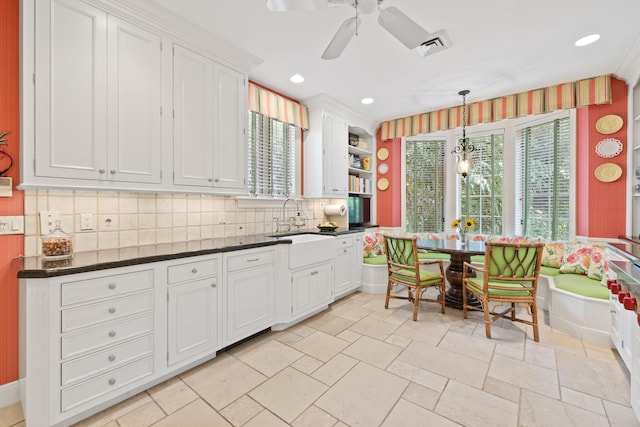 kitchen featuring hanging light fixtures, ceiling fan, light tile floors, white cabinets, and tasteful backsplash