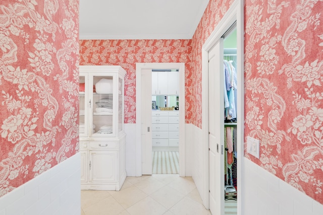 corridor with crown molding and light tile floors