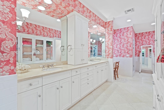 bathroom with double sink vanity, tile floors, and crown molding