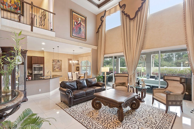 living room featuring a notable chandelier, a high ceiling, light tile floors, and sink