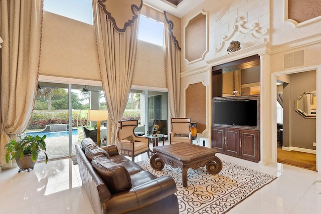 tiled living room featuring ceiling fan and a high ceiling