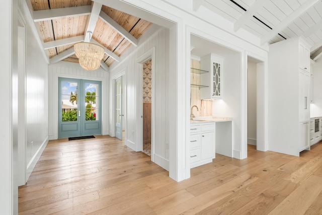 foyer featuring vaulted ceiling with beams, wood ceiling, french doors, light wood-type flooring, and an inviting chandelier