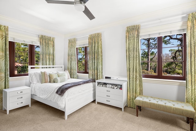 carpeted bedroom featuring ornamental molding and ceiling fan