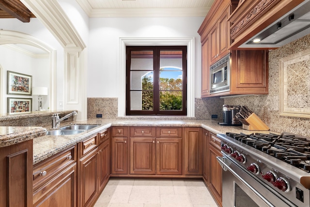 kitchen with backsplash, light tile flooring, appliances with stainless steel finishes, sink, and custom range hood