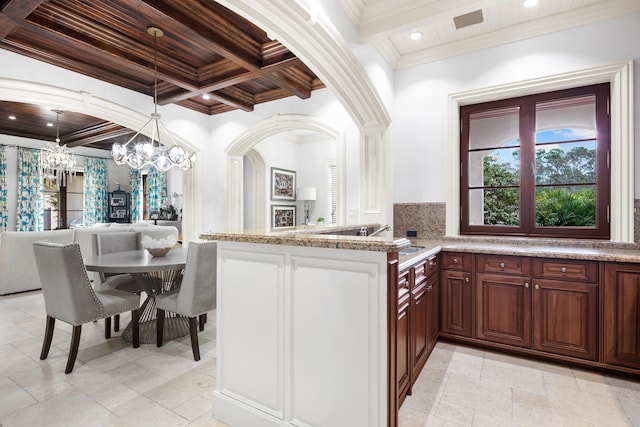 kitchen featuring a chandelier, a healthy amount of sunlight, coffered ceiling, and light tile floors