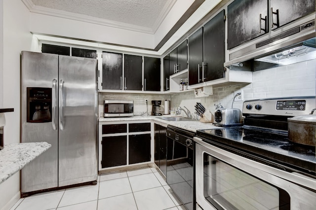 kitchen with sink, tasteful backsplash, a textured ceiling, light tile patterned flooring, and appliances with stainless steel finishes