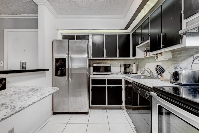 kitchen with tasteful backsplash, a textured ceiling, stainless steel appliances, sink, and light tile patterned flooring