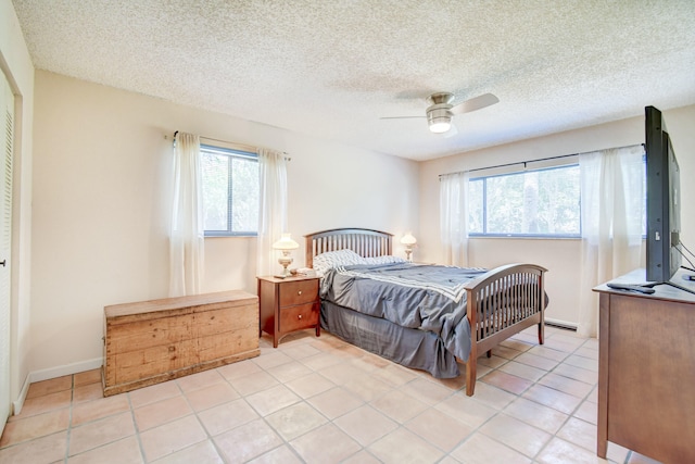 bedroom with ceiling fan, light tile patterned flooring, and multiple windows