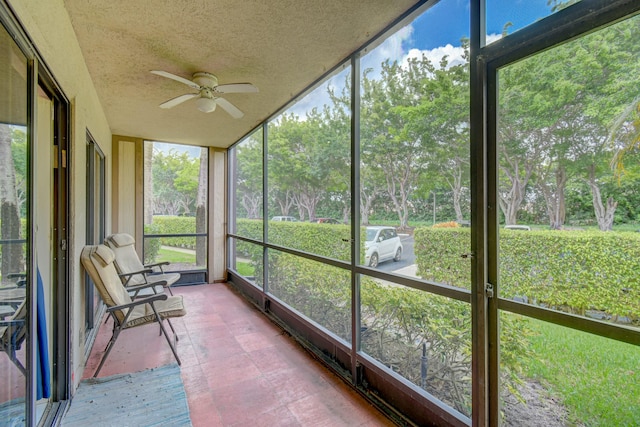 unfurnished sunroom with ceiling fan