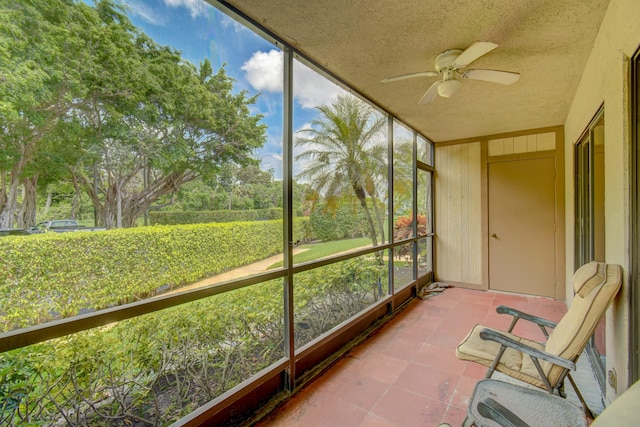 unfurnished sunroom featuring ceiling fan