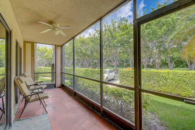 unfurnished sunroom featuring ceiling fan