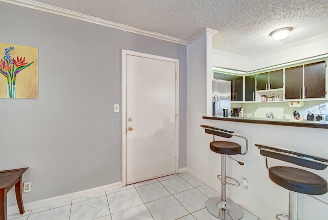 kitchen with stainless steel fridge with ice dispenser, a textured ceiling, ornamental molding, and light tile patterned flooring