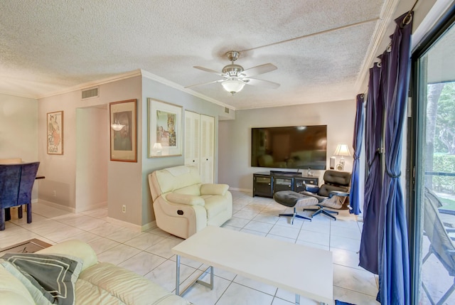 living room featuring ceiling fan, crown molding, light tile patterned floors, and a textured ceiling