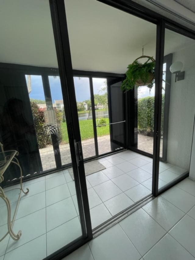 doorway with light tile flooring and expansive windows